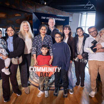 Members of the Short Strand Community Forum photographed with Judith Owens MBE, CEO Titanic Belfast, Paul Henry, Chair of Maritime Belfast Trust and Kerrie Sweeney MBE, CEO of Maritime Belfast Trust, at the entrance of the Titanic Experience